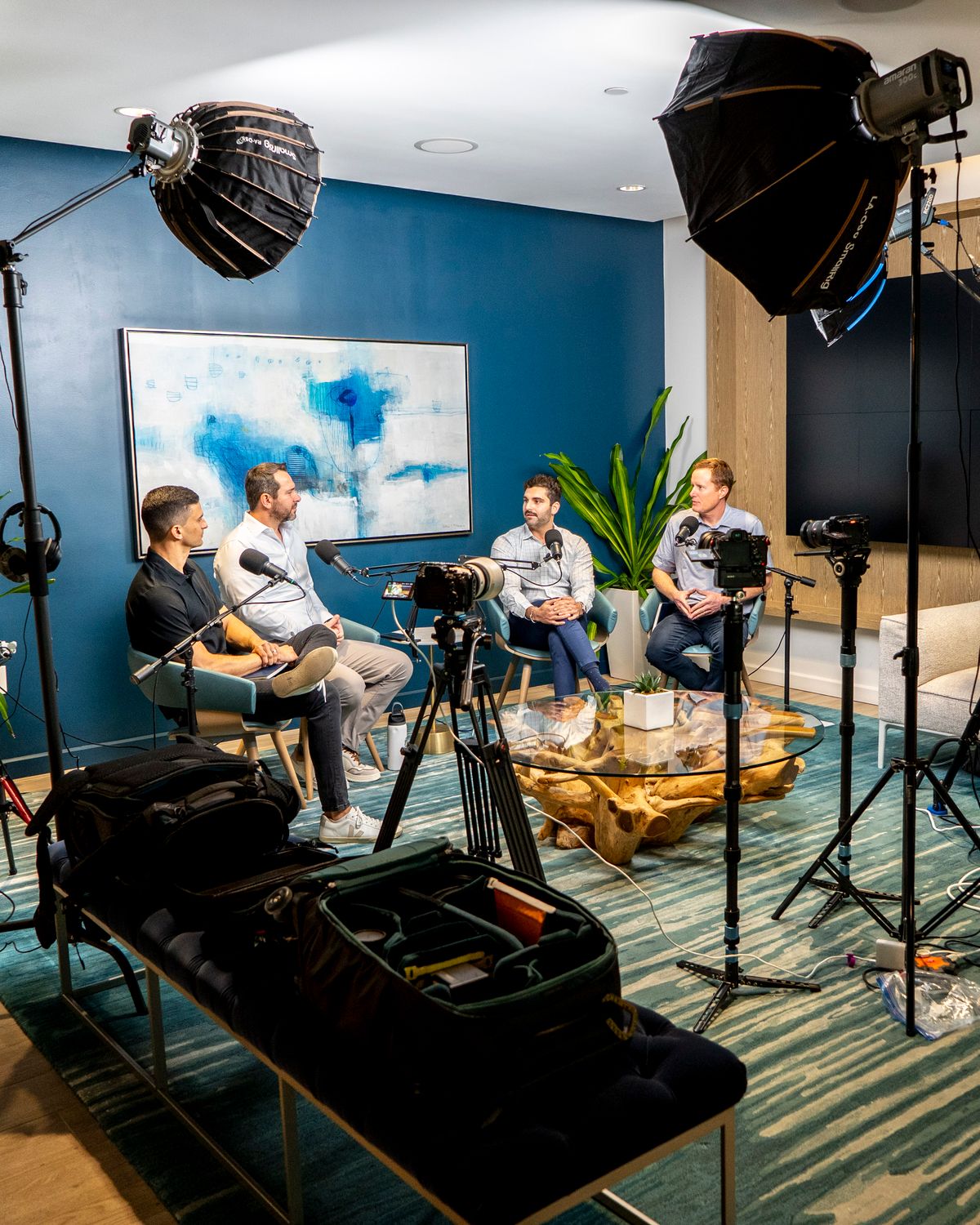 Four men seated in a studio setting, engaged in conversation.